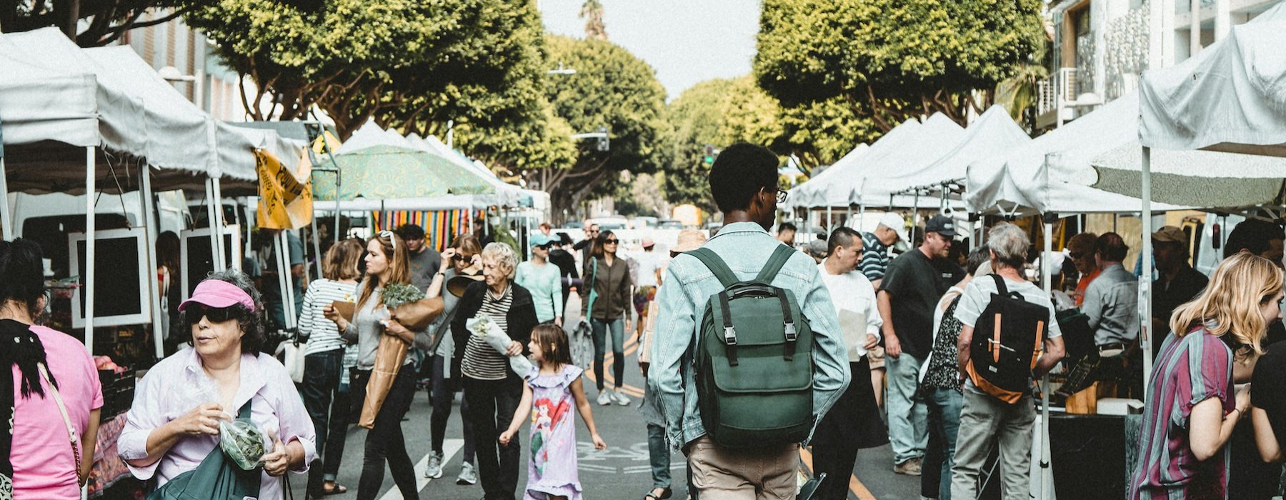 people walking through an open market