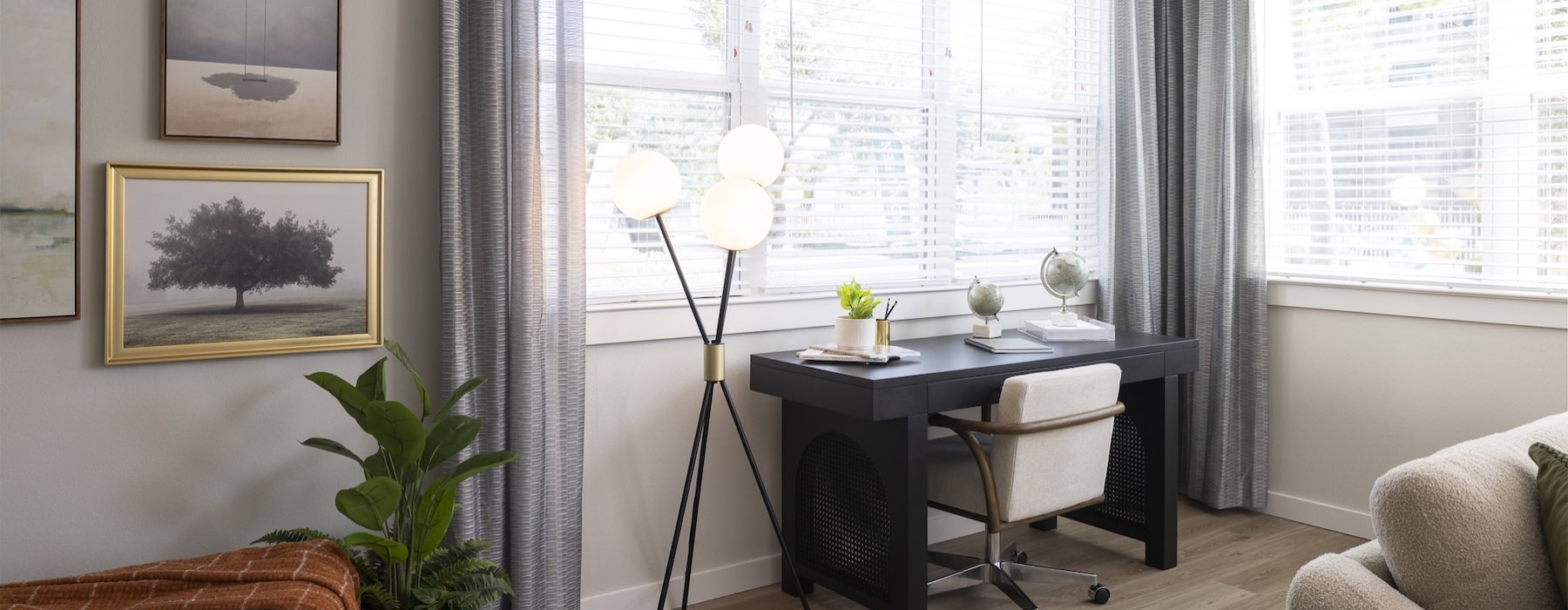 a living room with a desk and a window