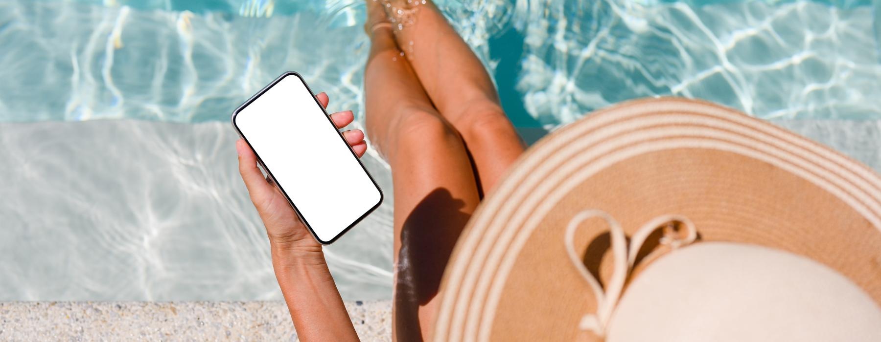 a person lying on a beach with a tablet and a phone